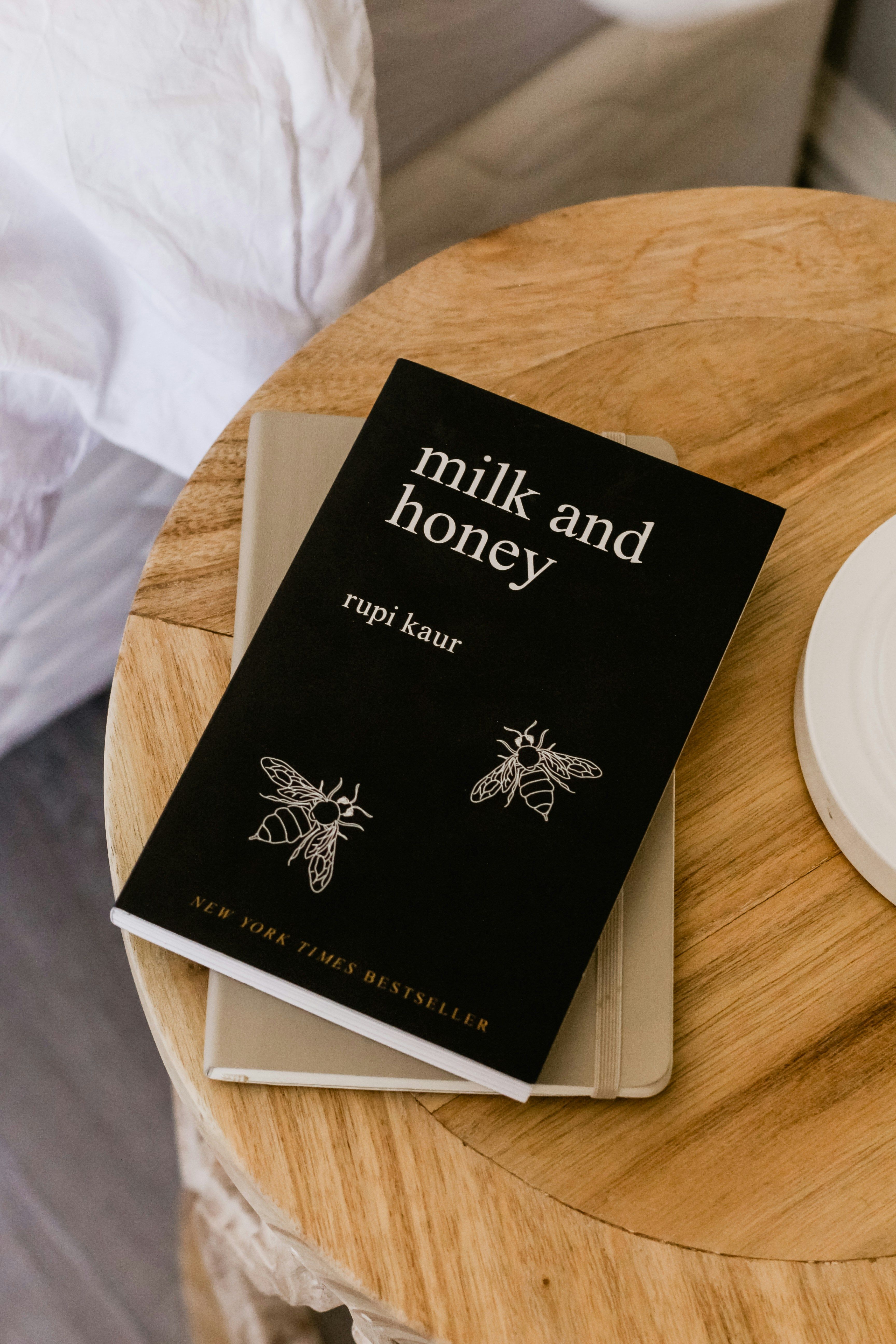 The book "Milk and Honey" by Rupi Kaur resting on a nightstand