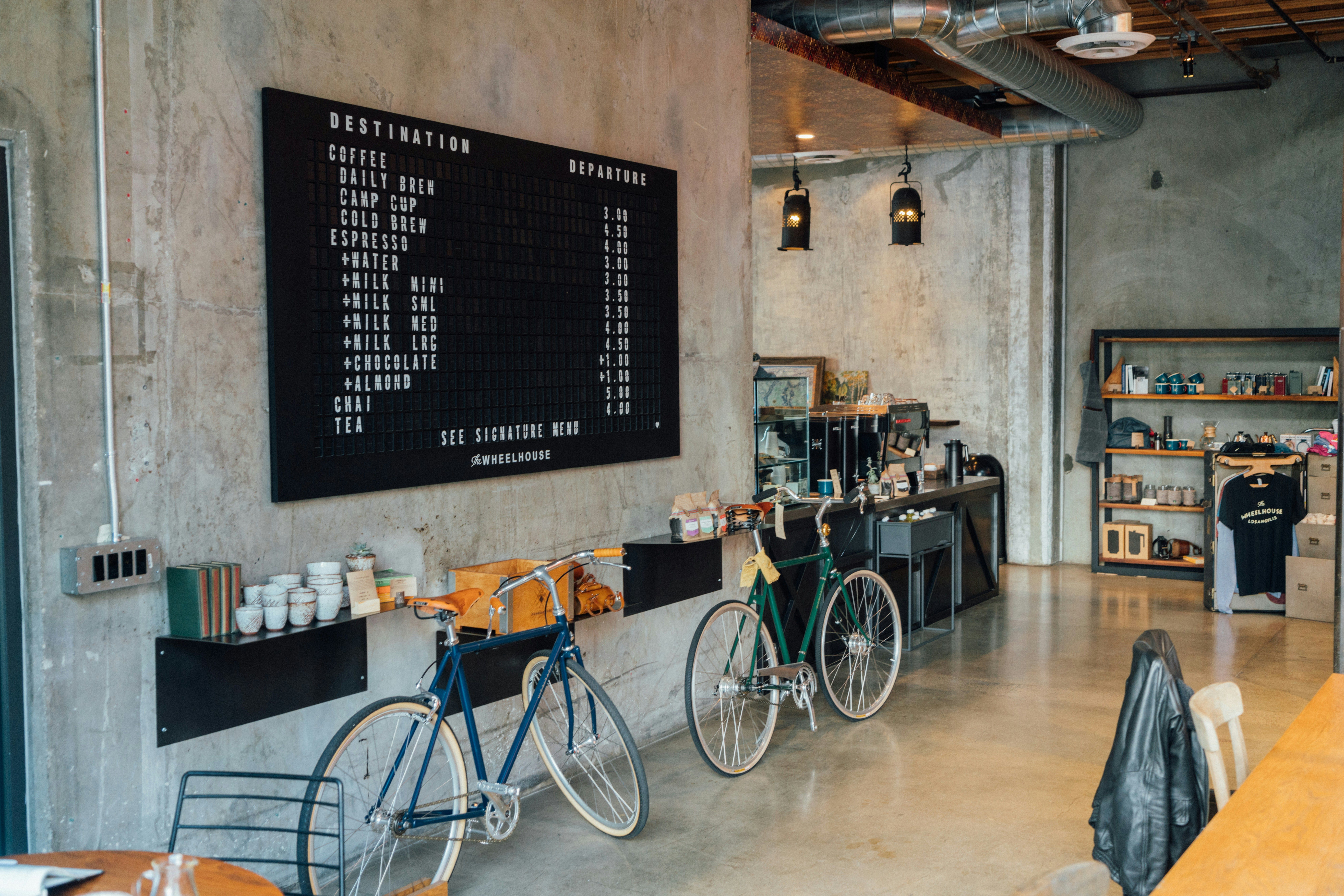 A concrete-walled café with two bikes parked by the counter